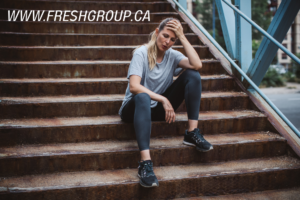 woman tired from jogging sitting on the stairs www.freshgroup.ca